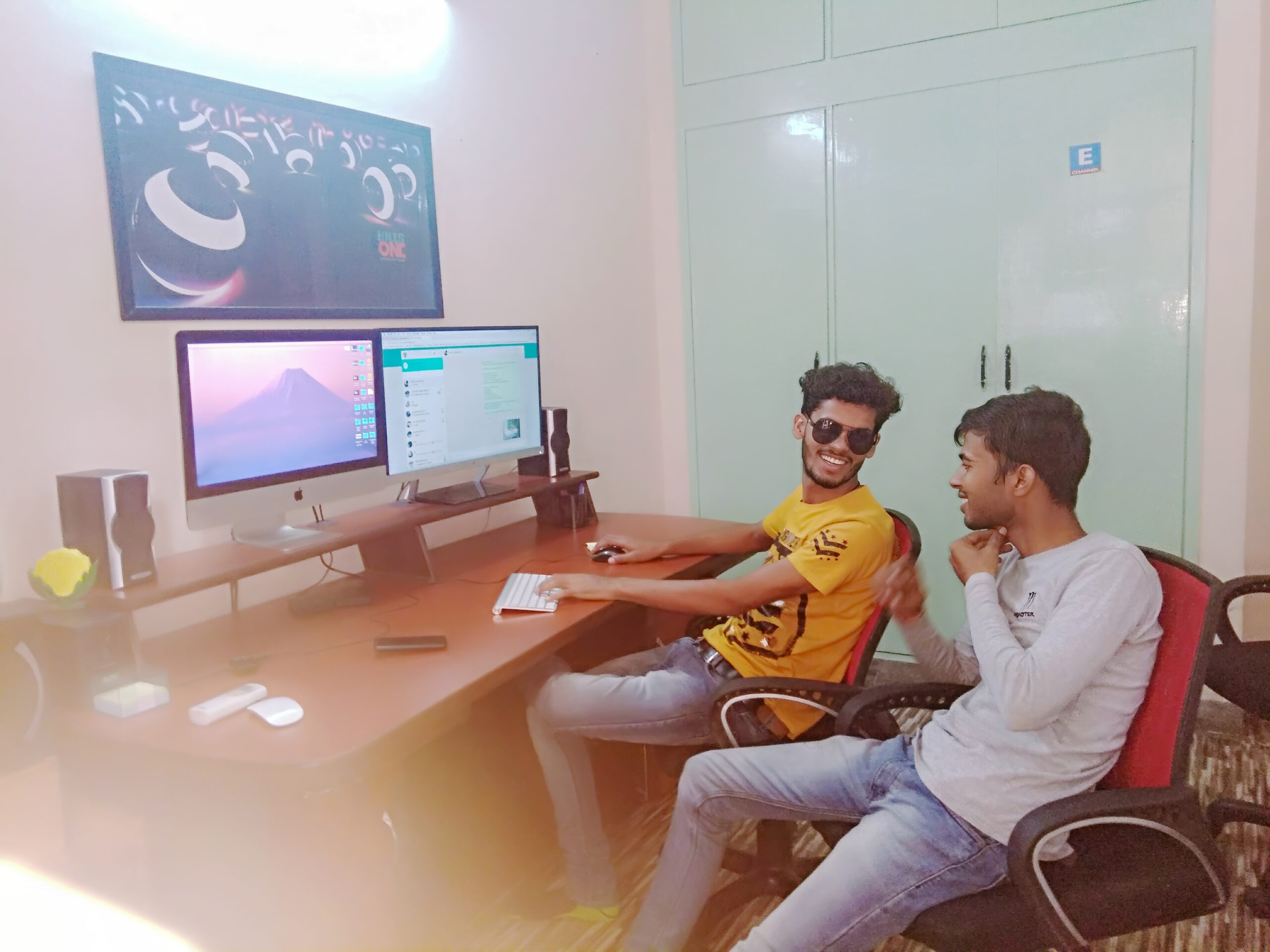 Payal Films owner and team members working in office with dual monitors and video editing setup for wedding photography business in Bihar