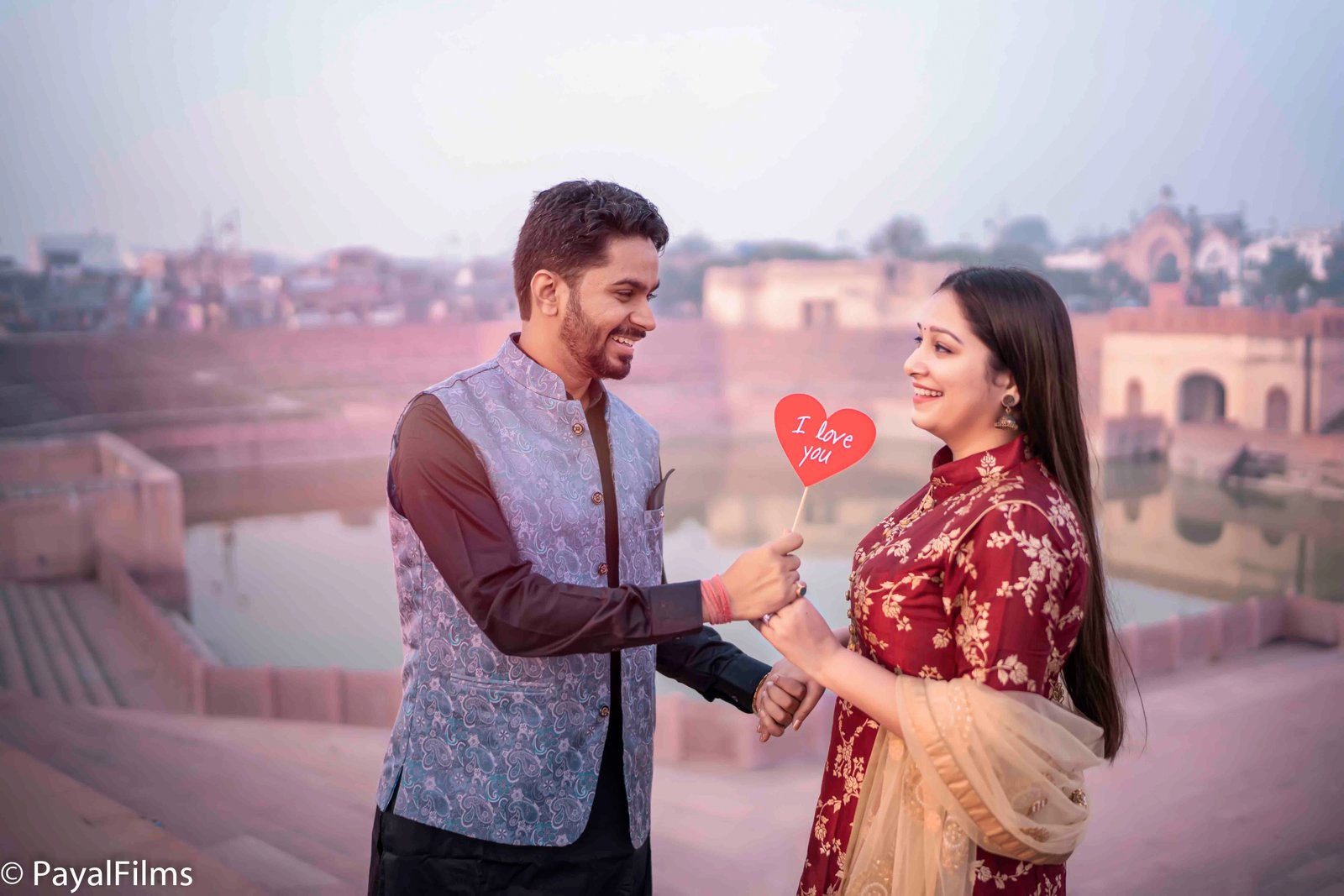 Pre-wedding couple holding decorative I Love You wooden sign by Payal Films Bihar