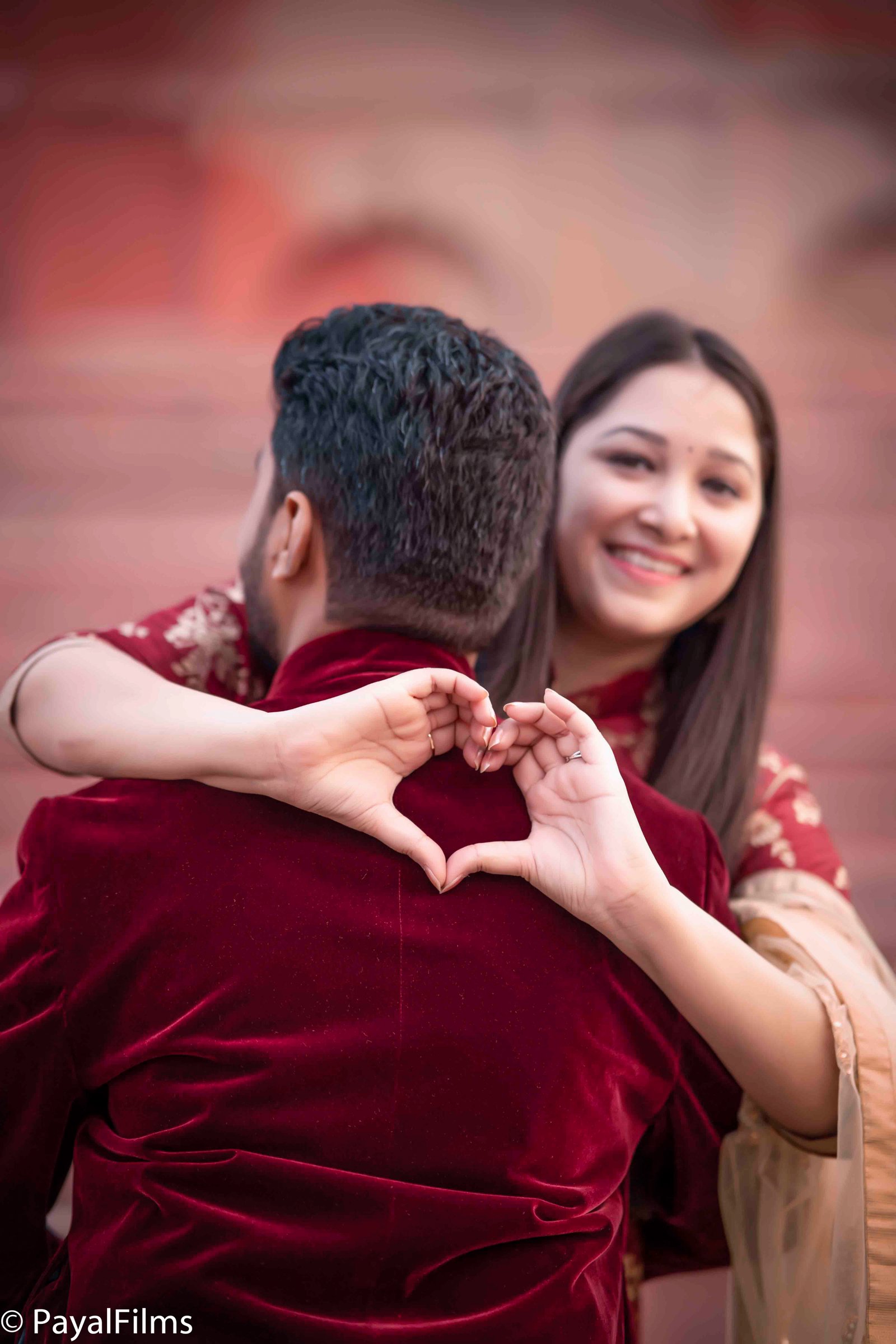 Romantic couple making heart shape with hands in matching ethnic attire by Payal Films Bihar