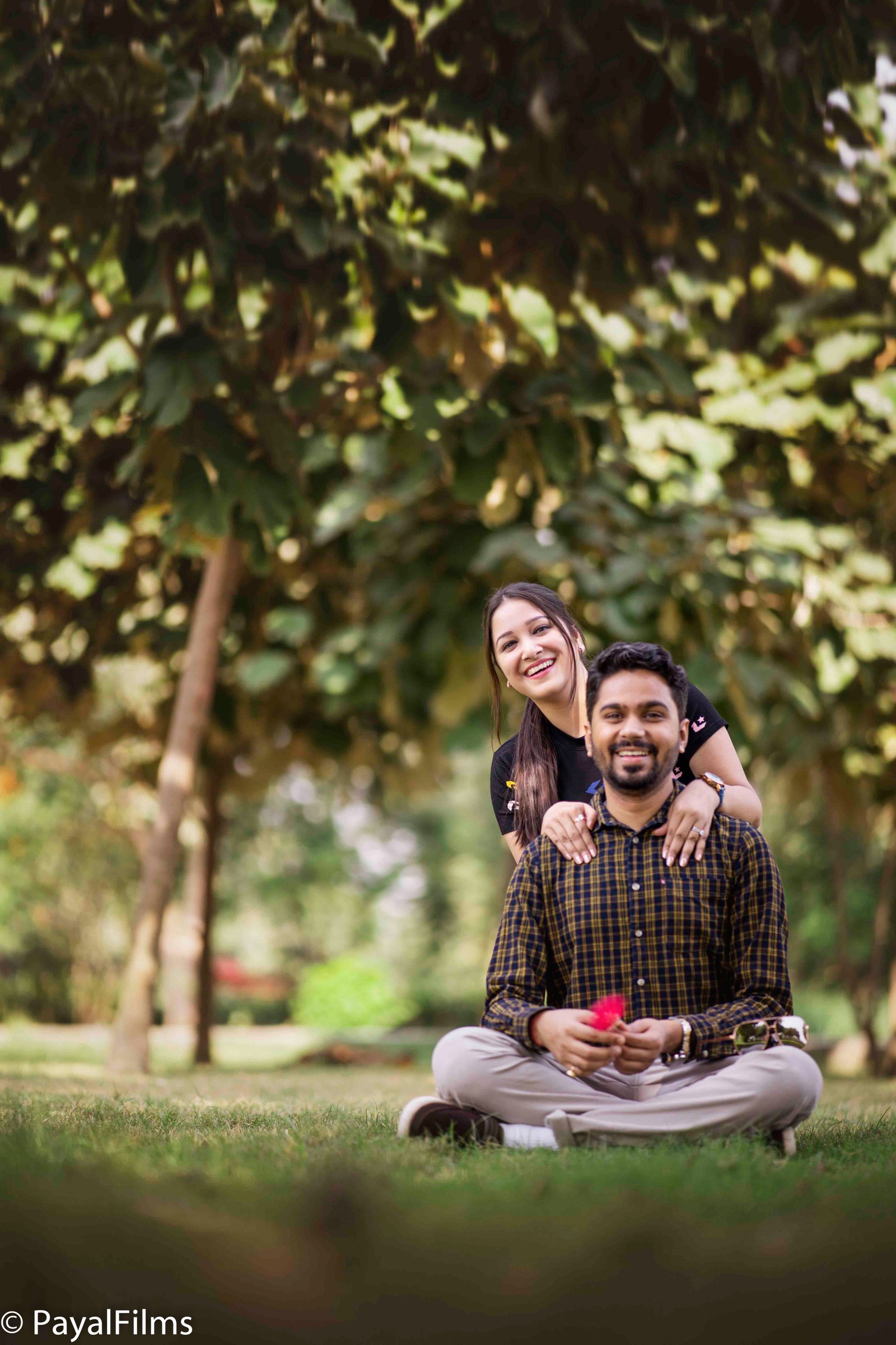 A romantic couple in matching maroon outfits sharing a loving gaze, captured by Payal Films in a cinematic portrait.