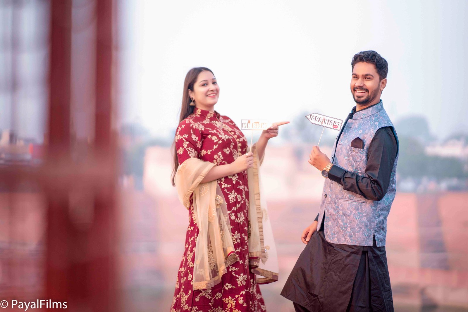 Joyful indian couple holding mr and mrs right props portrait by Payal Films Bihar