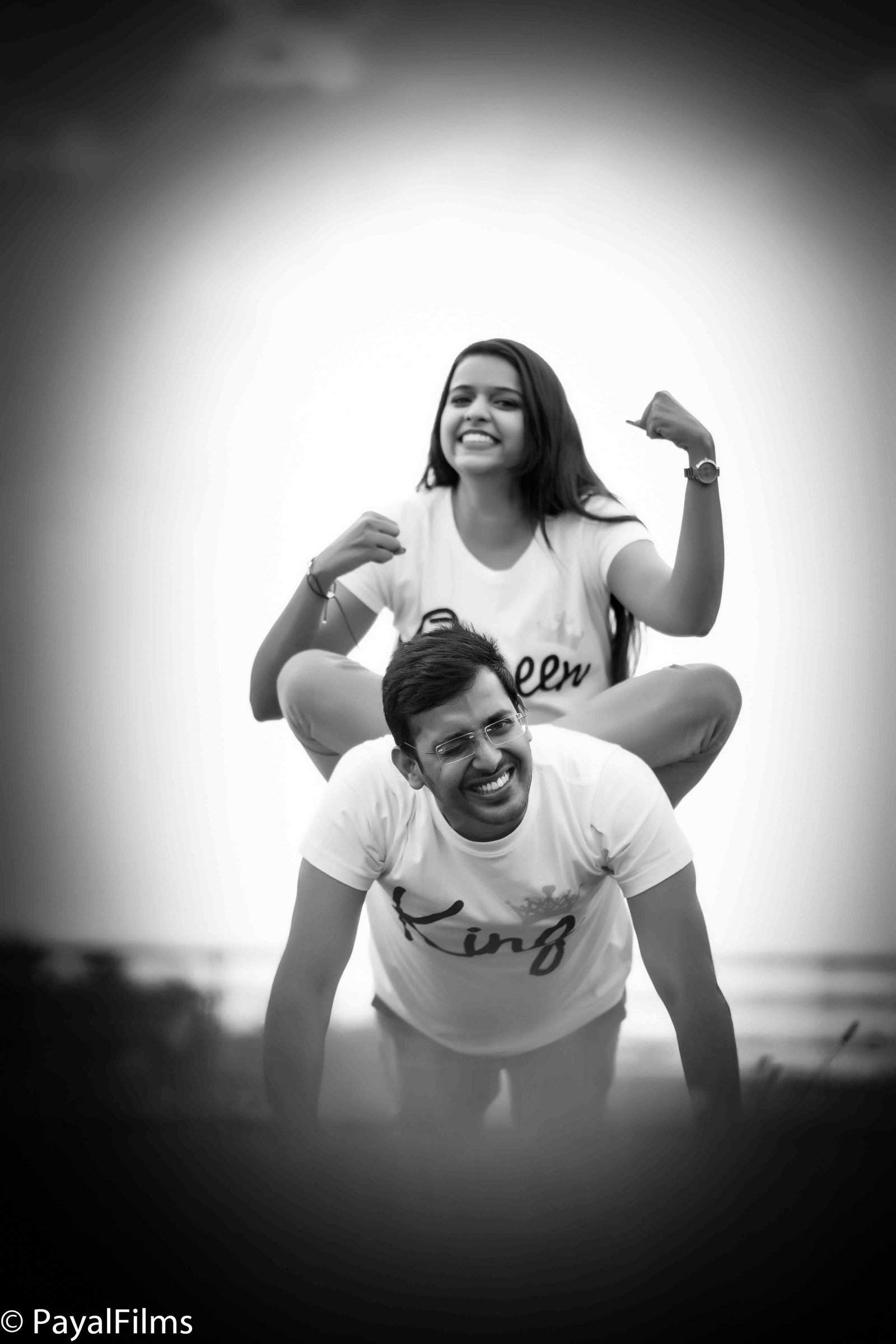 A playful couple wearing King and Queen t-shirts in a piggyback pose, captured by Payal Films in Khagaria.