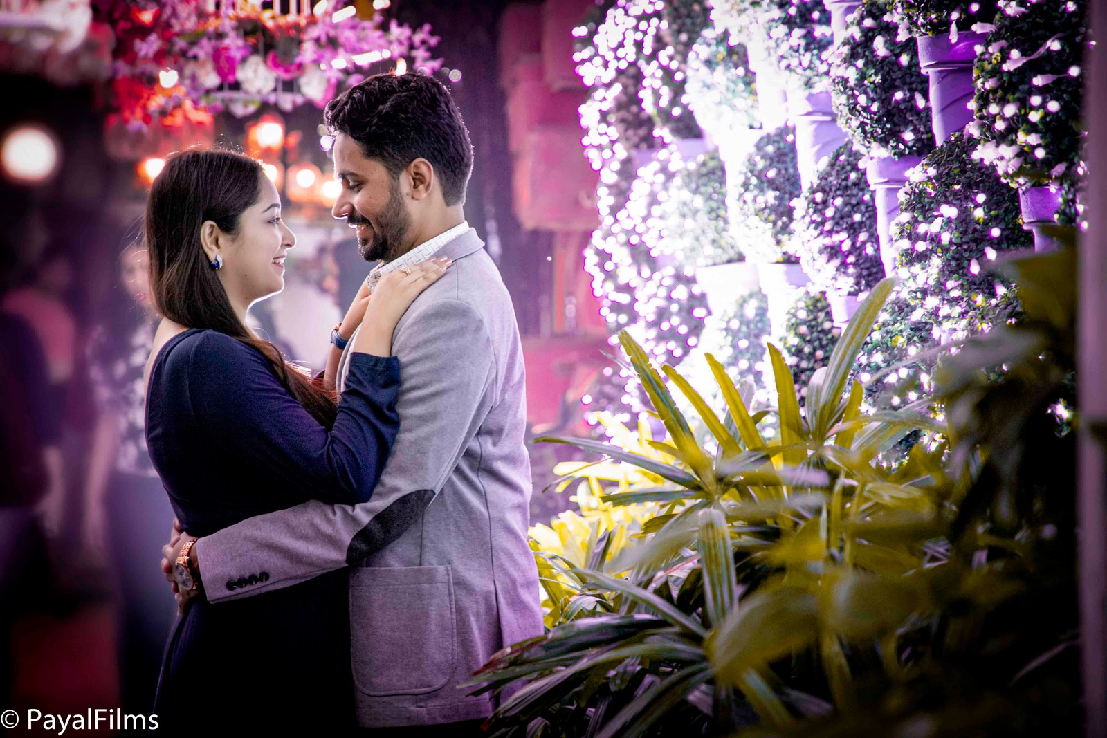 Couple sharing a romantic forehead kiss in traditional attire at a heritage site, captured by Payal Films.