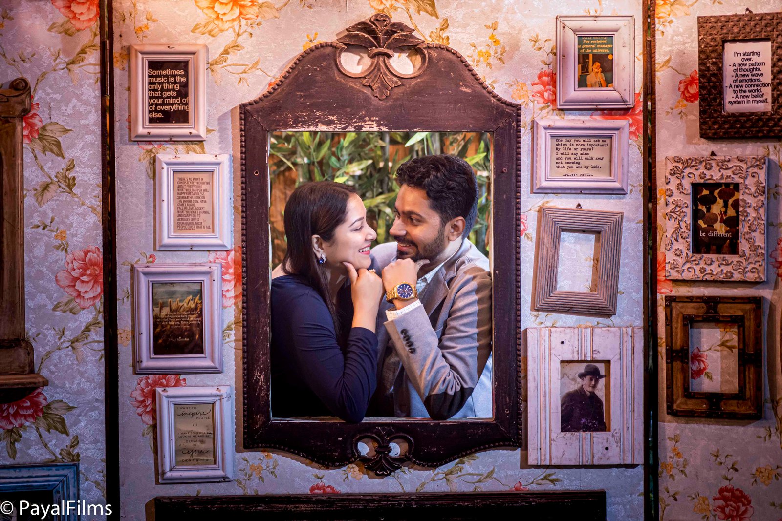 Romantic couple holding hands across a cafe table in a cinematic portrait by Payal Films