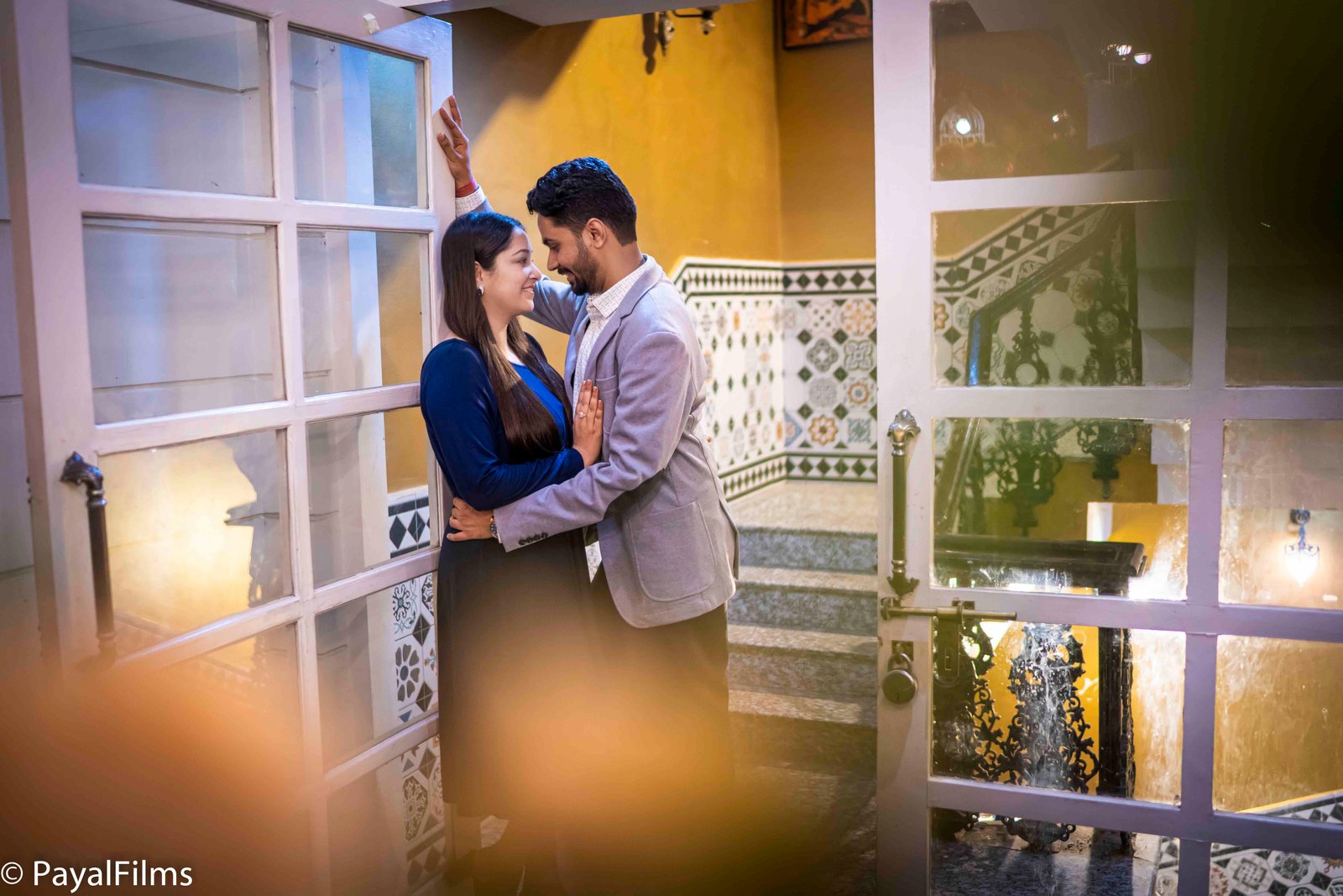 Romantic couple posing near a classic doorway captured by Payal Films in Khagaria.