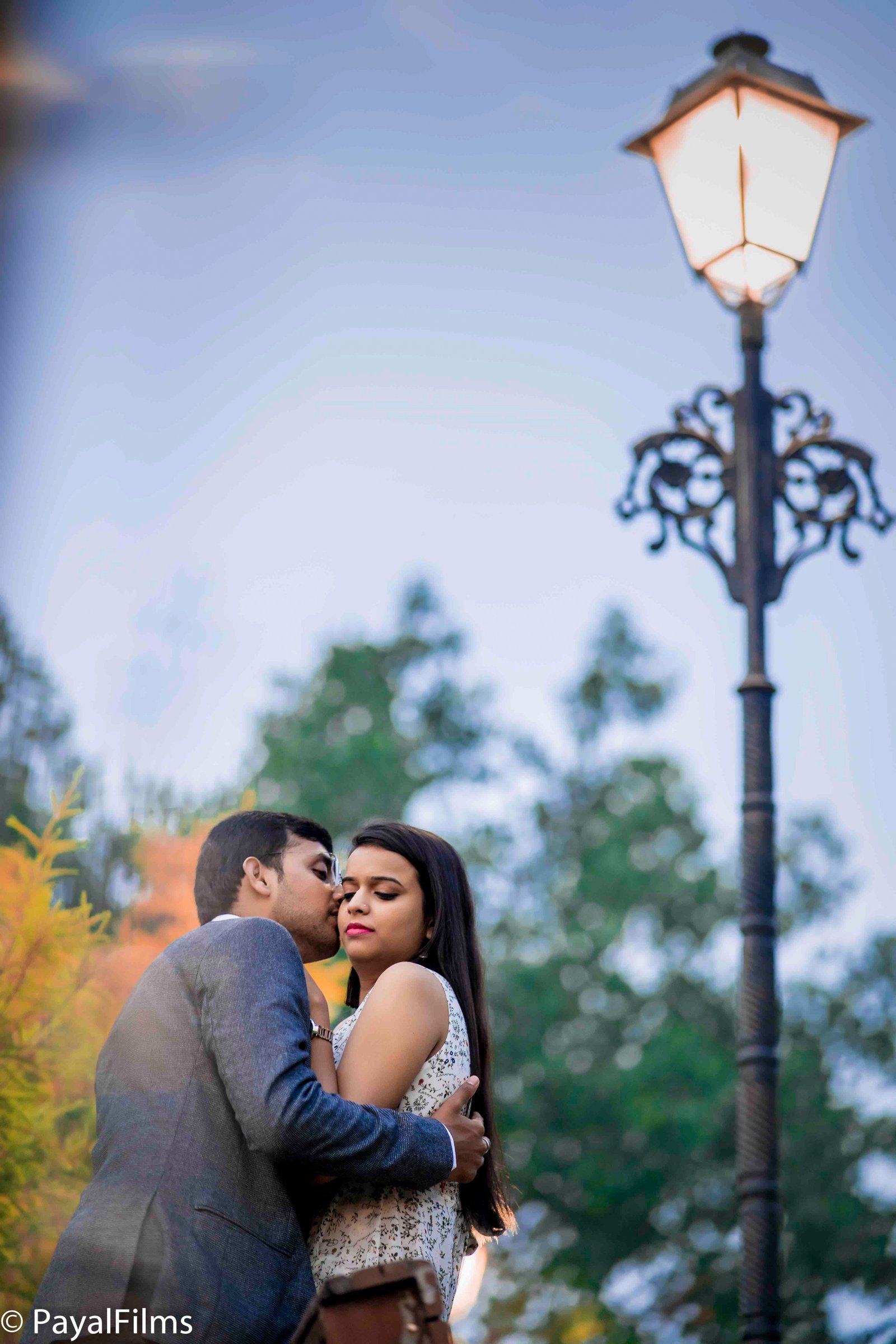Romantic pre-wedding portrait of a couple embracing under a vintage lamppost by Payal Films in Khagaria.
