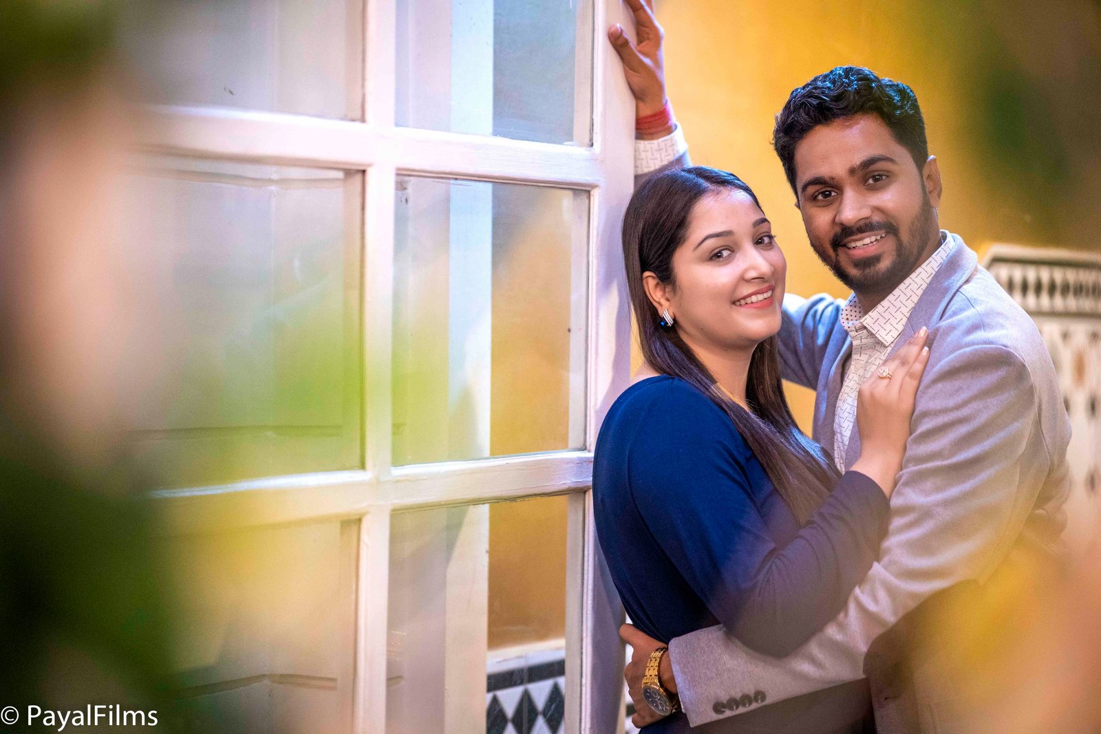 Smiling couple hugging and posing together by Payal Films