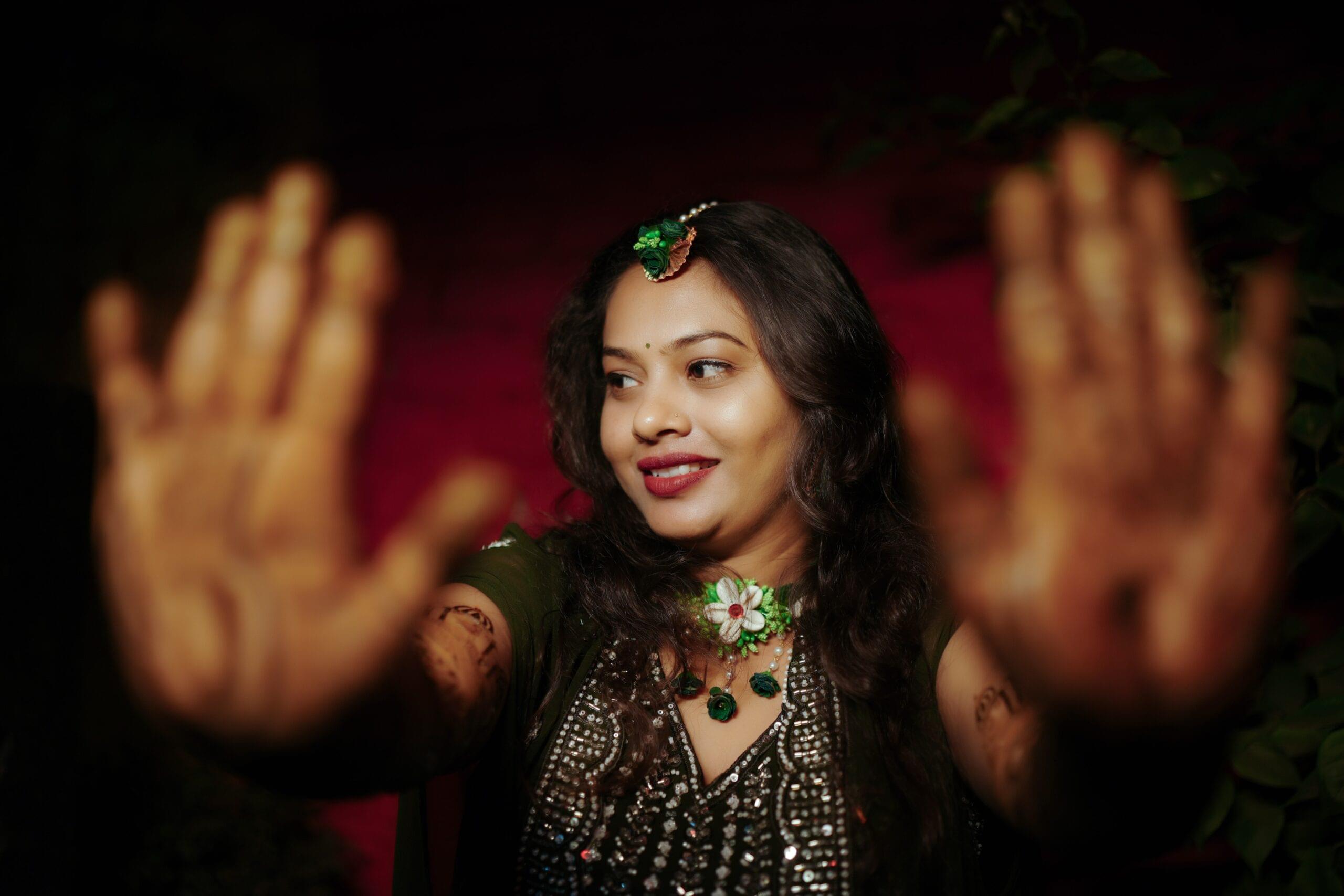 Beautiful bride in green studded blouse with white flower jewelry and maang tika during mehendi ceremony, professional wedding photography by Payal Films Bihar
