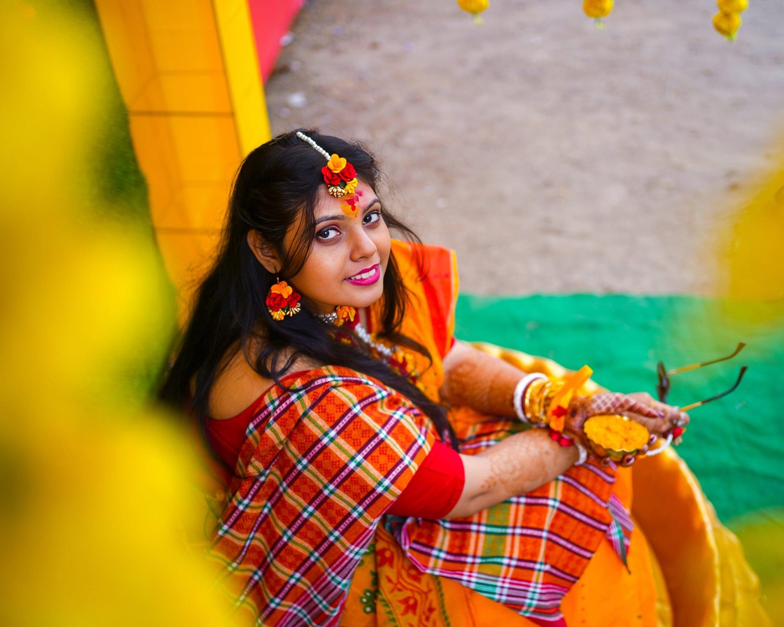 A woman wearing a traditional Indian sari sits gracefully on a yellow chair, showcasing vibrant colors and cultural elegance - Payal Films Bihar