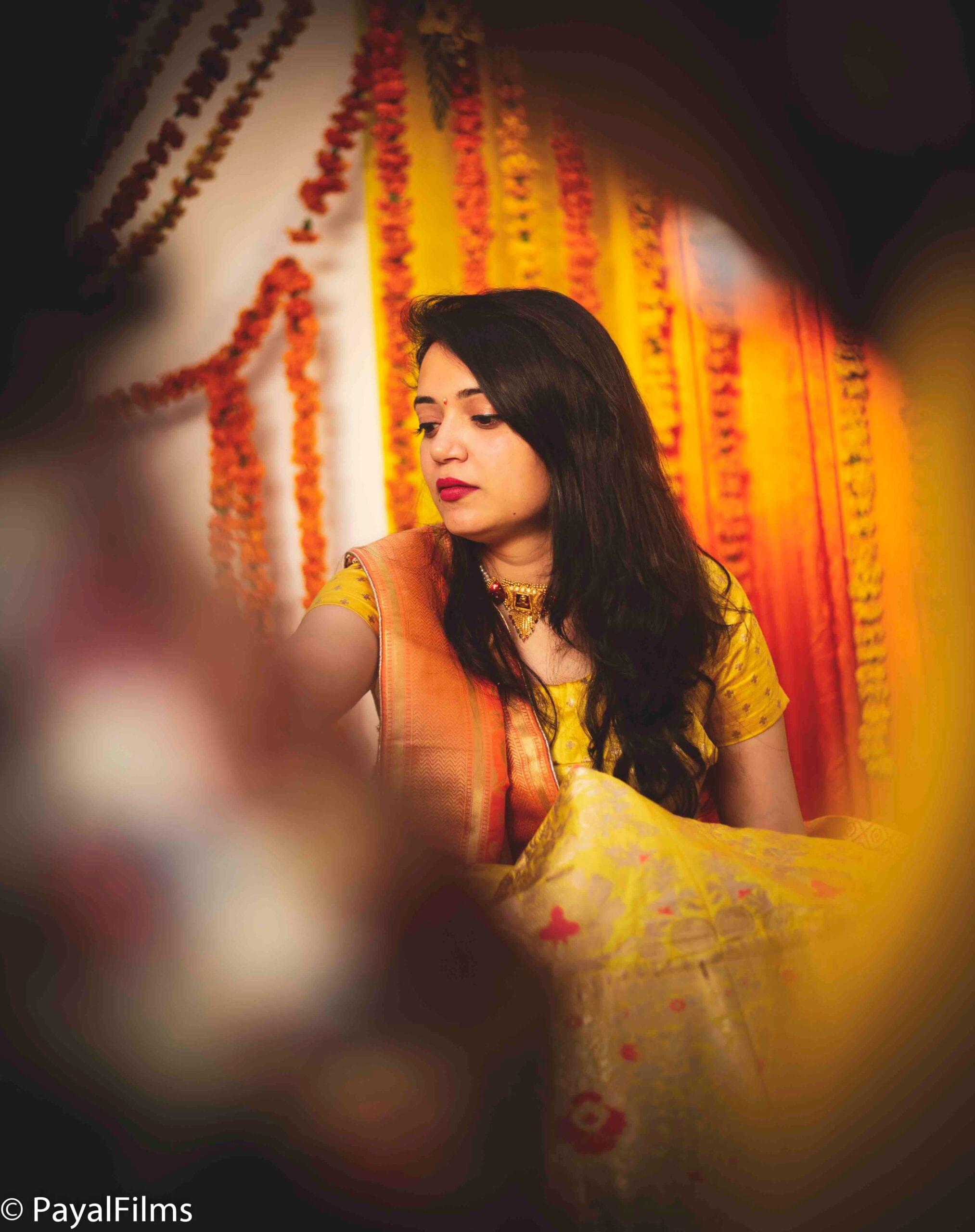 Payal Films bride in traditional yellow saree with creative marigold backdrop at wedding in Bihar