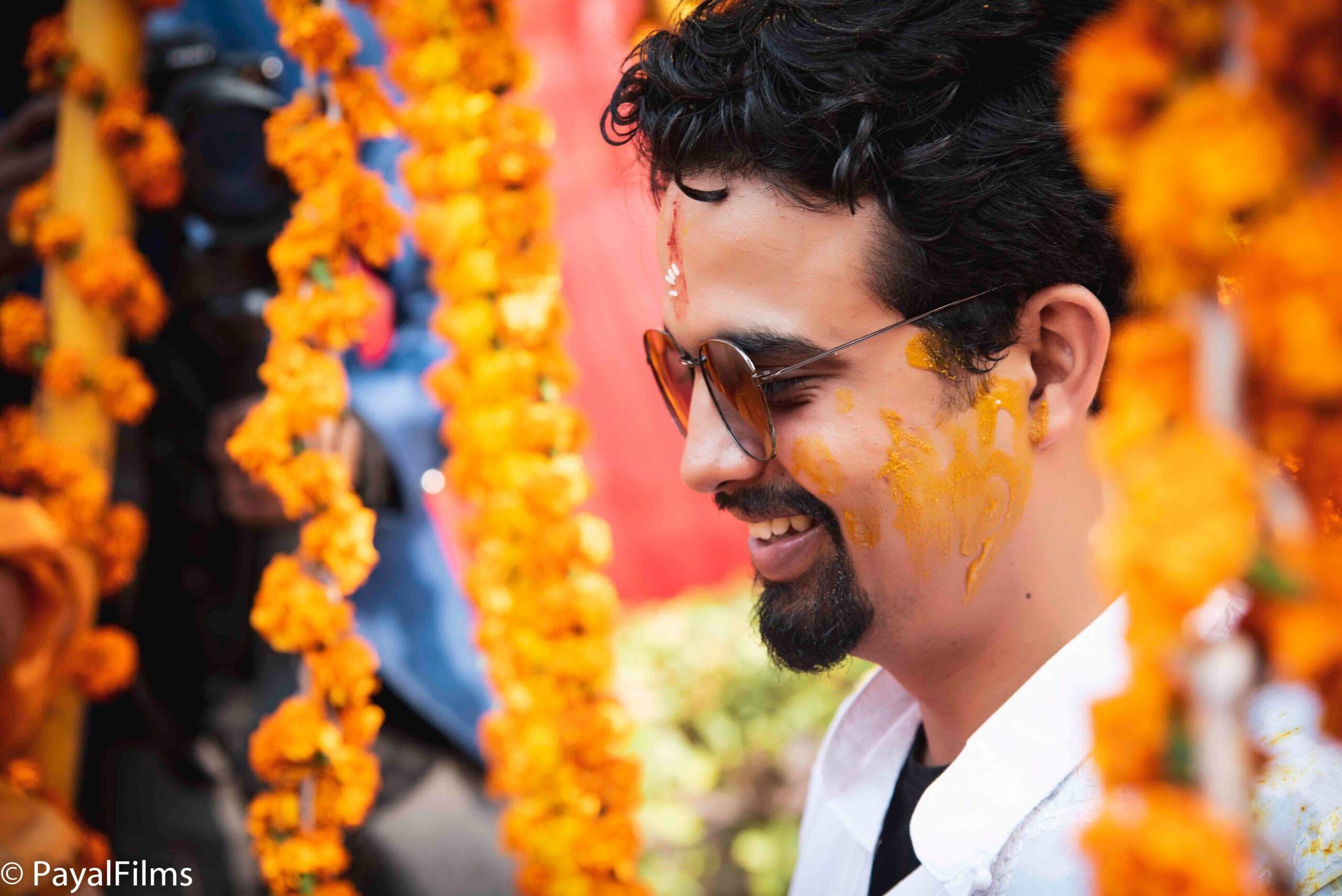 Payal Films close-up of groom at traditional haldi ceremony with marigold decorations, Bihar